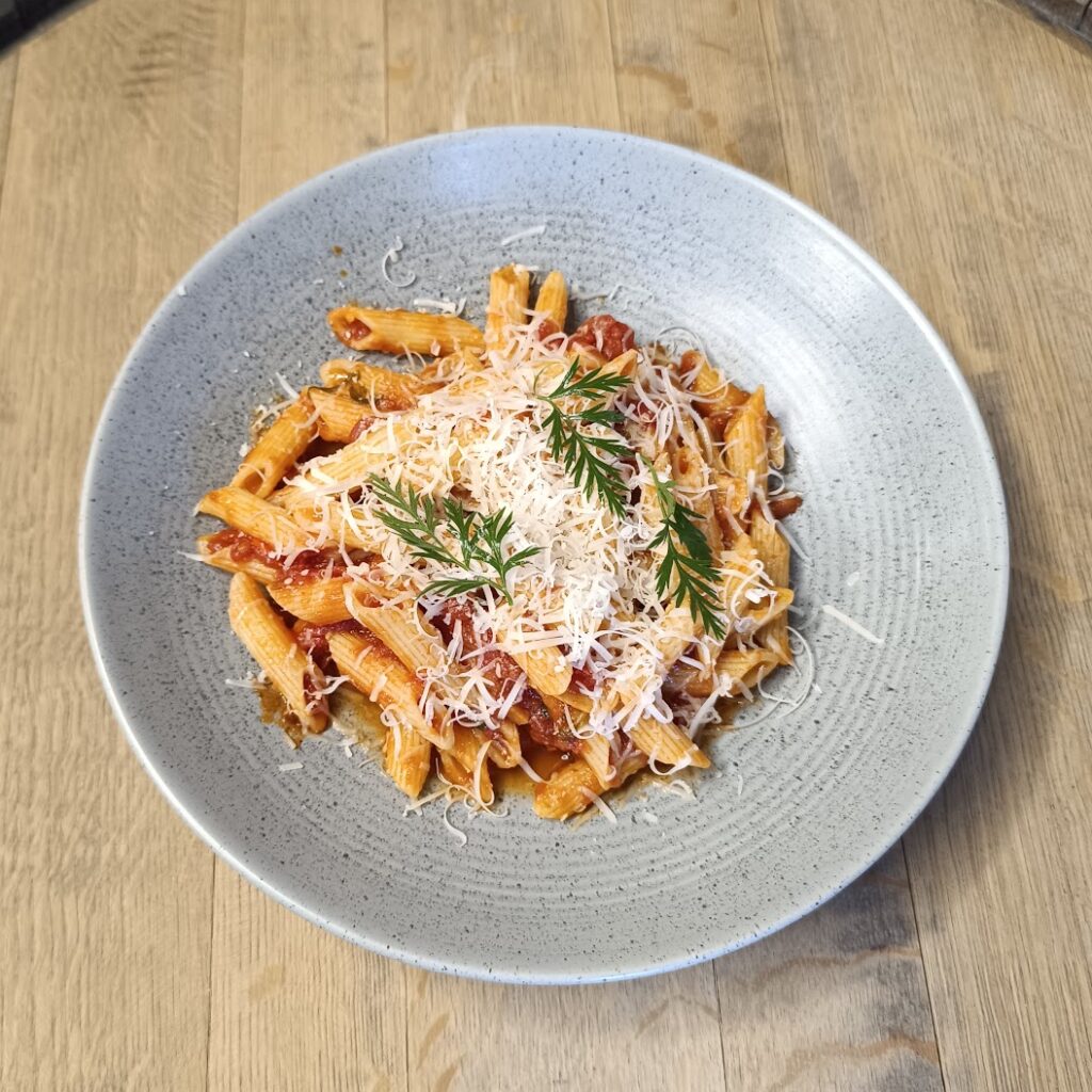 Penne s pikantní tomatovou omáčkou, pančetou a Grana Padano